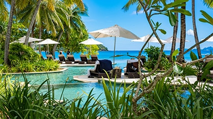 Tropical resort pool overlooking the ocean.